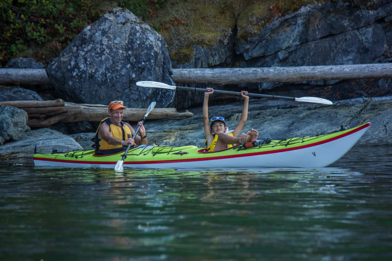 A father and son kayak in Desolation Sound on one of our guided kayaking resort packages