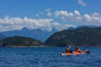 Two guests exploring Desolation SOund and the Coast Mountains on a double kayak