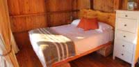 A handcrafted log bed in a bright, warm west coast cabana