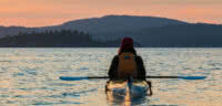 A female kayaker enjoying a sunset in Desolation Sound