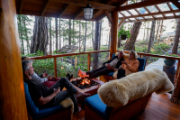 Four friends sitting around a propane fireplace in the Cabana Cafe